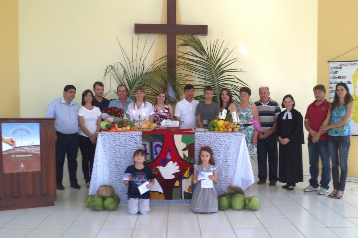 Membros da Comunidade em Campos de Júlio (12 famílias no total) com cartaz e cofrinhos da Campanha em frente ao altar!